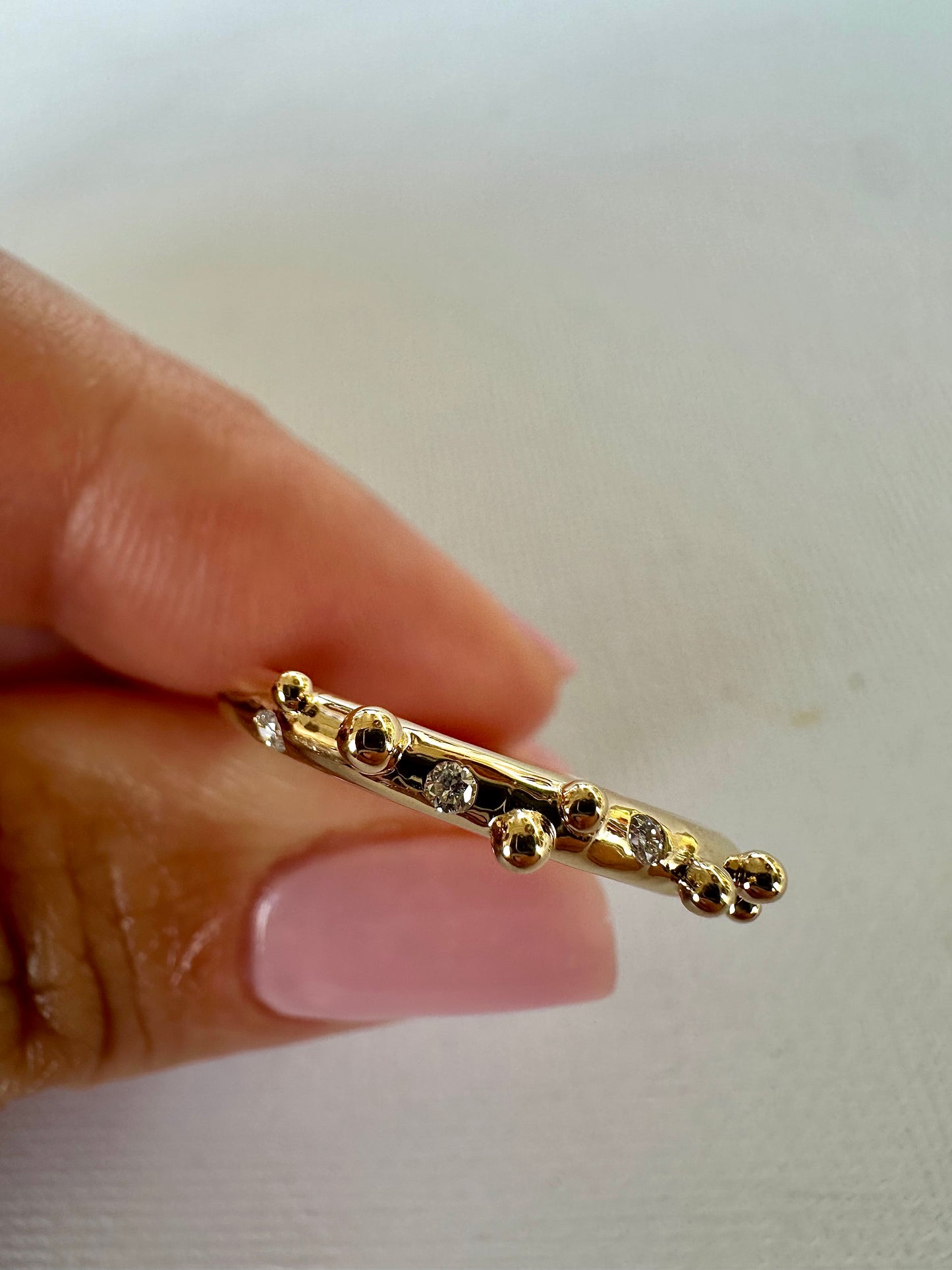Elegant thin Diamond band, hand-crafted in 18k gold, this thin gold band features a smooth D shape band with gold granulations and 4 flushed diamonds of 1.4mm diameter each placed randomly between the granules.| Ella Creations jewelry