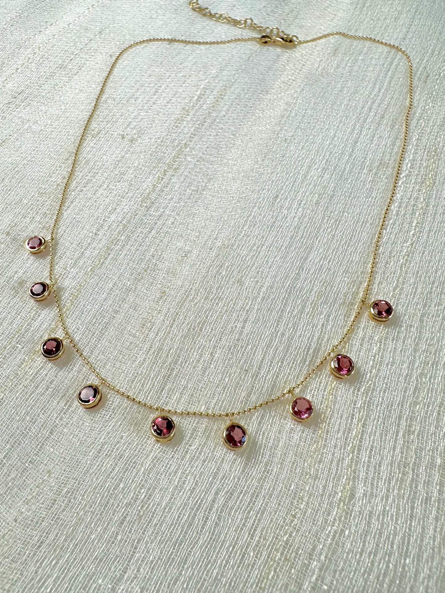 Handcrafted 18k Pink Tourmaline Station Necklace featuring nine pink tourmalines bezel set and dangling from a dainty ball chain necklace. This necklace comes with a chain extender for an adjustable length | Ella Creations Jewelry