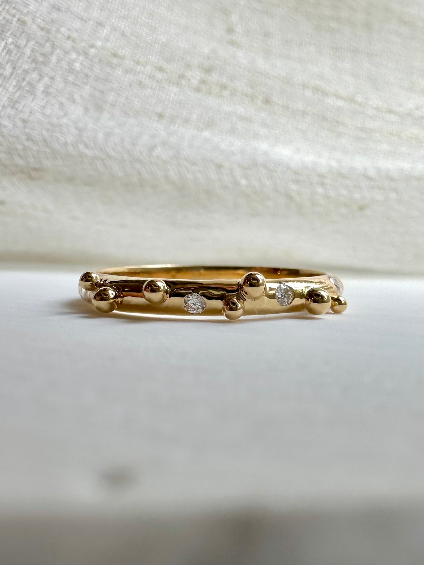 Elegant thin Diamond band, hand-crafted in 18k gold, this thin gold band features a smooth D shape band with gold granulations and 4 flushed diamonds of 1.4mm diameter each placed randomly between the granules | Ella Creations jewelry
