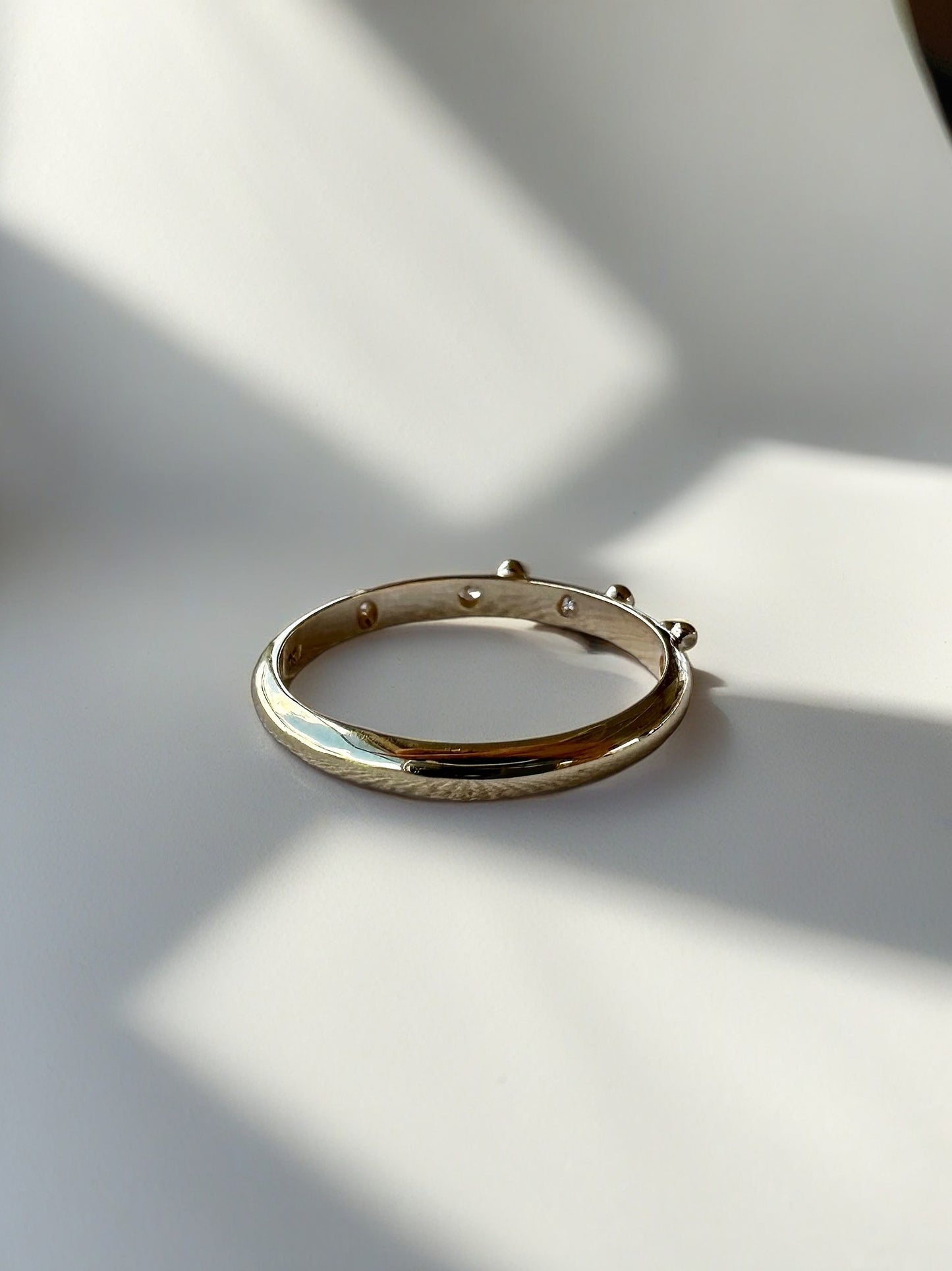 Elegant thin Diamond band, hand-crafted in 18k gold, this thin gold band features a smooth D shape band with gold granulations and 4 flushed diamonds of 1.4mm diameter each placed randomly between the granules. | Ella Creations jewelry