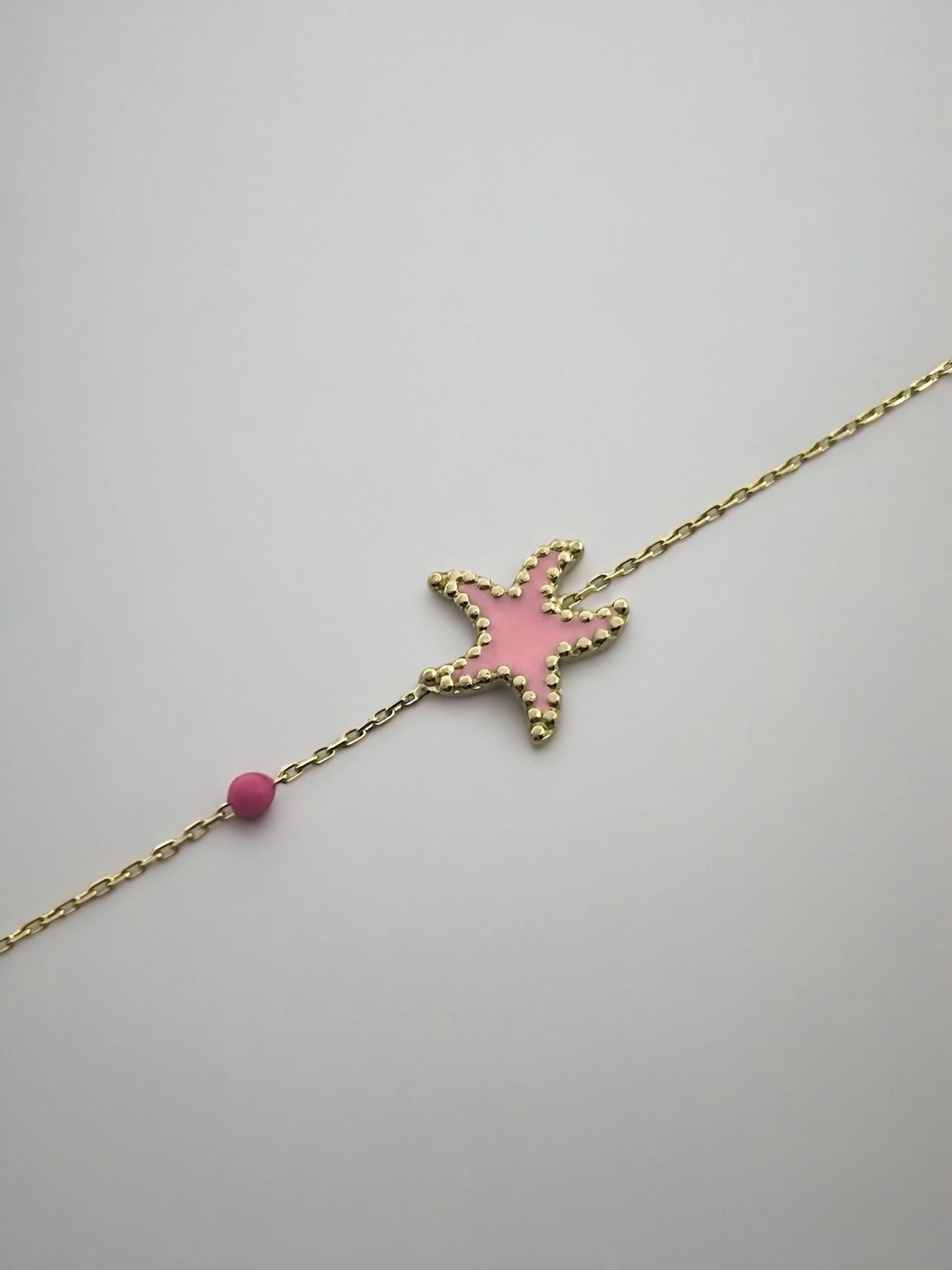 Exquisite Starfish Bracelet features a starfish charm at its center, available in Bright Turquoise and baby Pink finishes. Handcrafted in 18k gold and you can opt whether to have the charm only or an addition to a gold or enamel bead. | Ella Creations Jewelry
