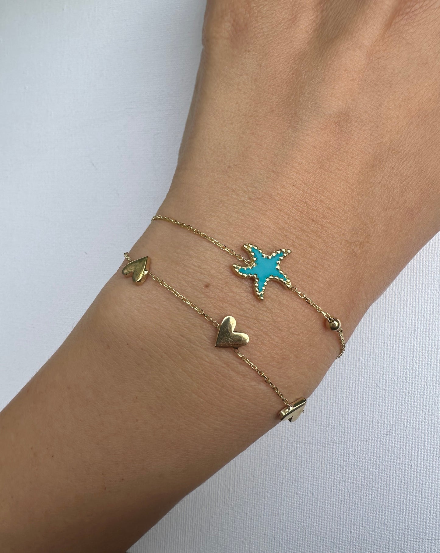 Exquisite Starfish Bracelet features a starfish charm at its center, available in Bright Turquoise and baby Pink finishes. Handcrafted in 18k gold and you can opt whether to have the charm only or an addition to a gold or enamel bead. | Ella Creations Jewelry