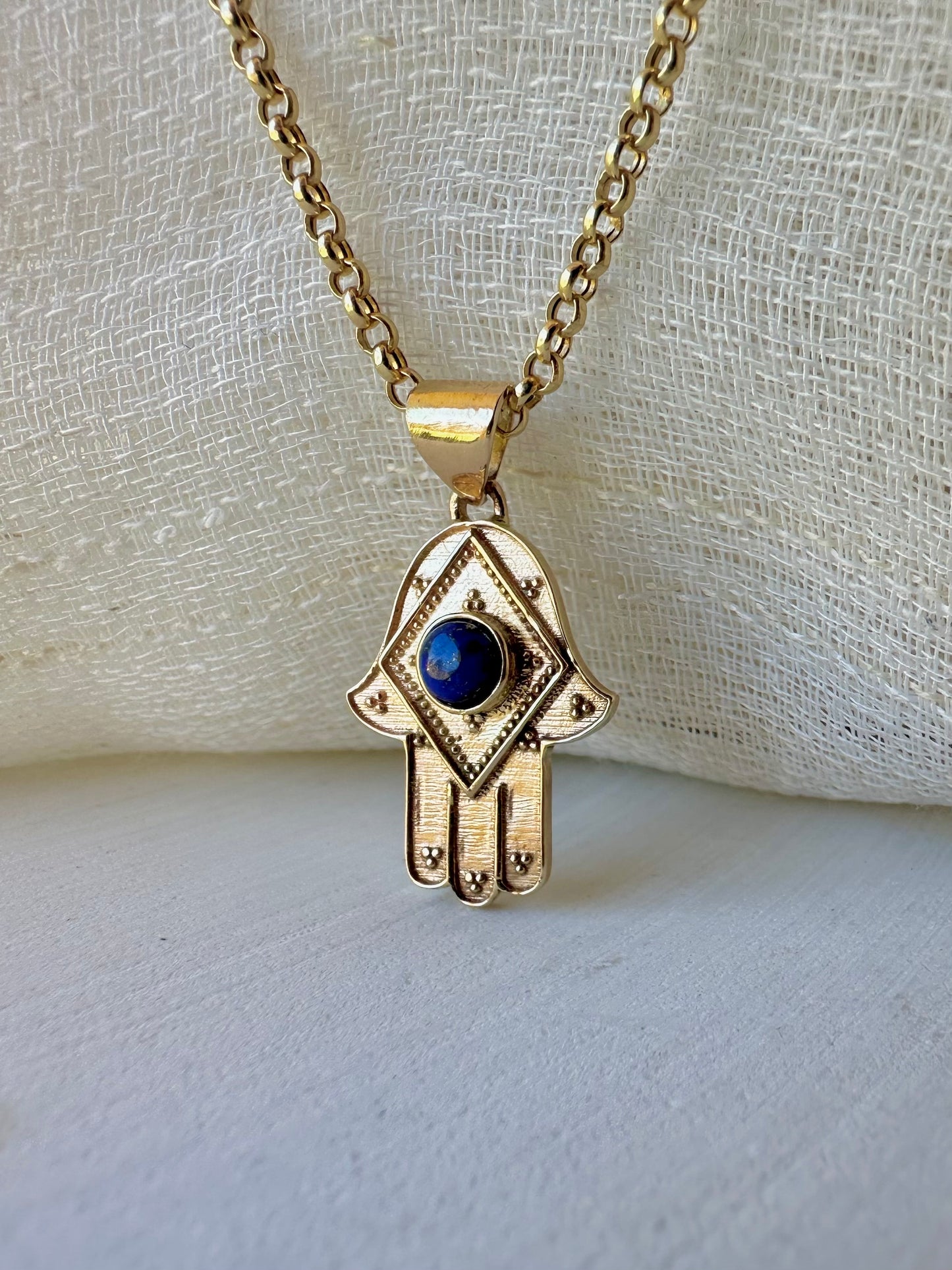 Stylish Gold Hamza Pendant adorned with aLapis Blue Stone at the center. Customizable in 14K or 18K