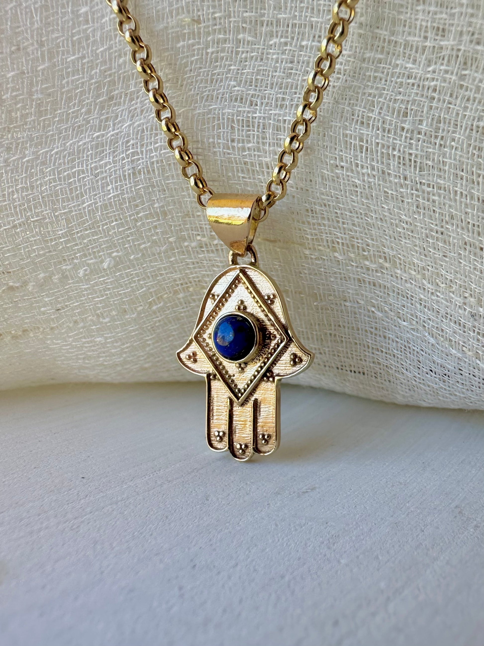 Stylish Gold Hamza Pendant adorned with aLapis Blue Stone at the center. Customizable in 14K or 18K