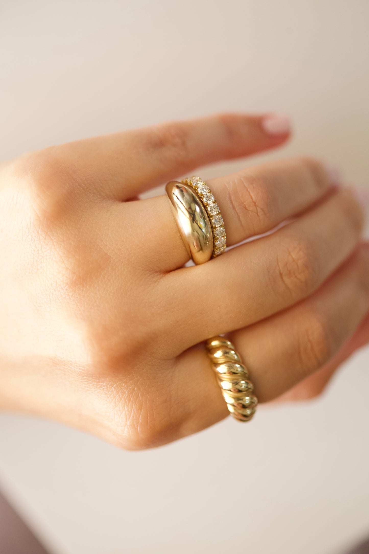 Chunky gold dome ring stacked with diamond eternity band and the Croissant Ring
