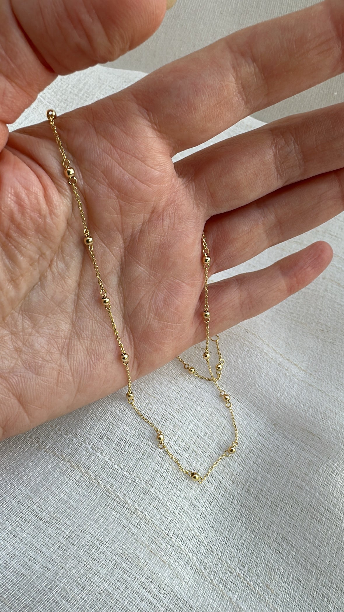 Delicate ball chain handcrafted in 18 karat gold featuring 2.5mm gold beads individually and manually wrapped onto the chain | Ella Creations Jewelry