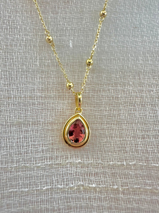 Pink Tourmaline pendant, set into a custom, two-tiered 18k gold bezel that matches the stone's pear shape. The pendant has a solid gold back with an opening behind the stone to allow the light to best reflect the stone shade and sparkle.