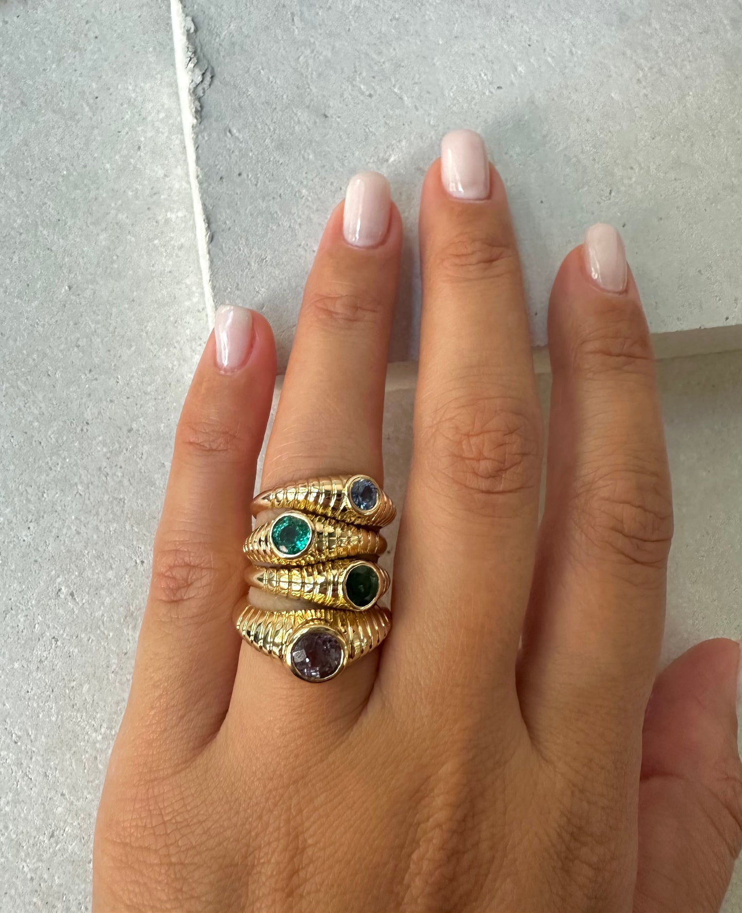 Mina Natural Emerald Ring features a unique design that combines modern elements with a vintage-inspired aesthetic. It's a custom made ring showcasing a 5mm bezel set stone at its center which you can select among a Natural emerald, peridot or London Blue Topaz. The beautiful intricate ribbed pattern gives the ring a contemporary look and the central stone further enhances the elegance of this ring.