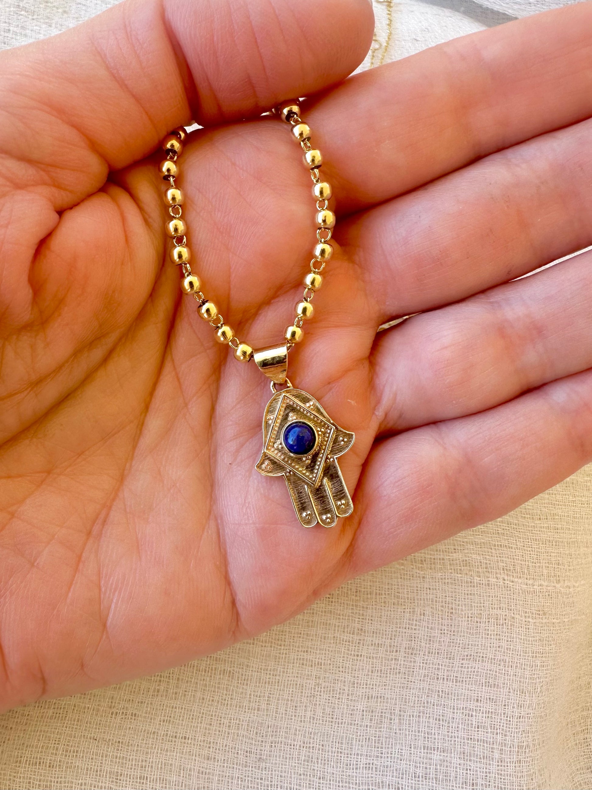Stylish Gold Hamza Pendant adorned with a Lapis Lazuli Stone at the center. Customizable in 14K or 18K