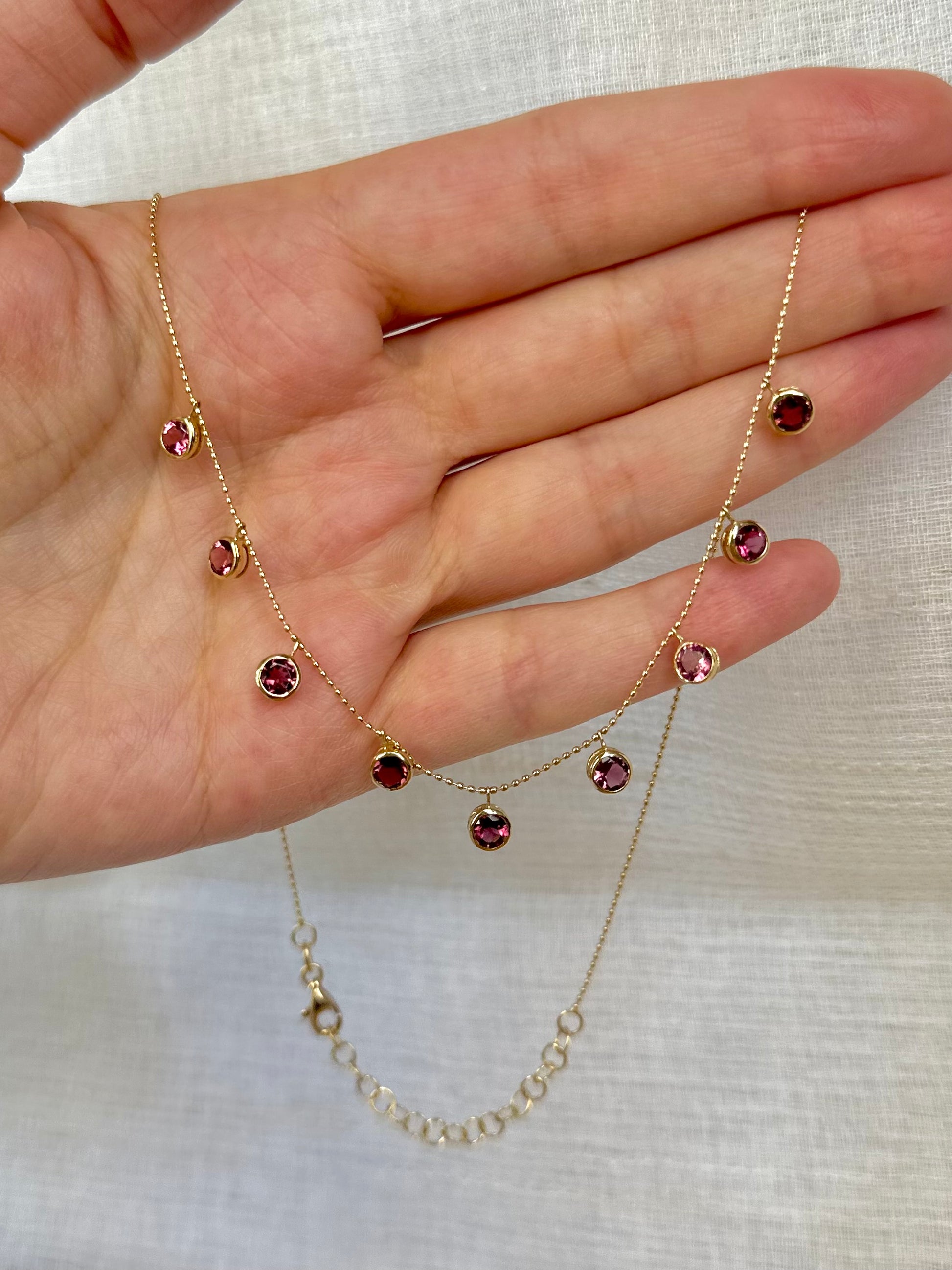 Handcrafted 18k Pink Tourmaline Station Necklace featuring nine pink tourmalines bezel set and dangling from a dainty ball chain necklace. Perfect as October Birthstone gift | Ella Creations Jewelry